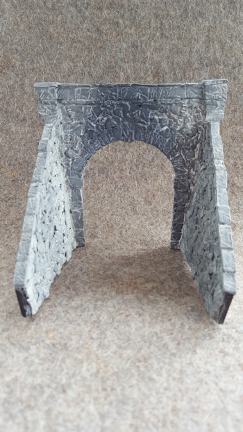 Thin dilute wash of off-white acrylic to define mortar and give some tonal variation. The darker area over the portal is where the train smoke stains the stones